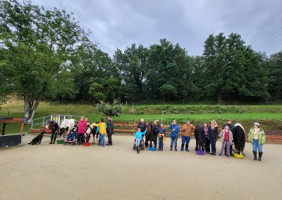 Gruppe von Menschen mit Pferden auf dem Reitplatz