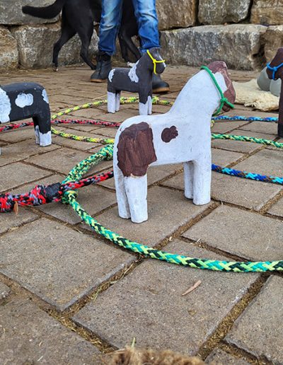 Anordnung von vier kleinen, bemalten Holzpferden